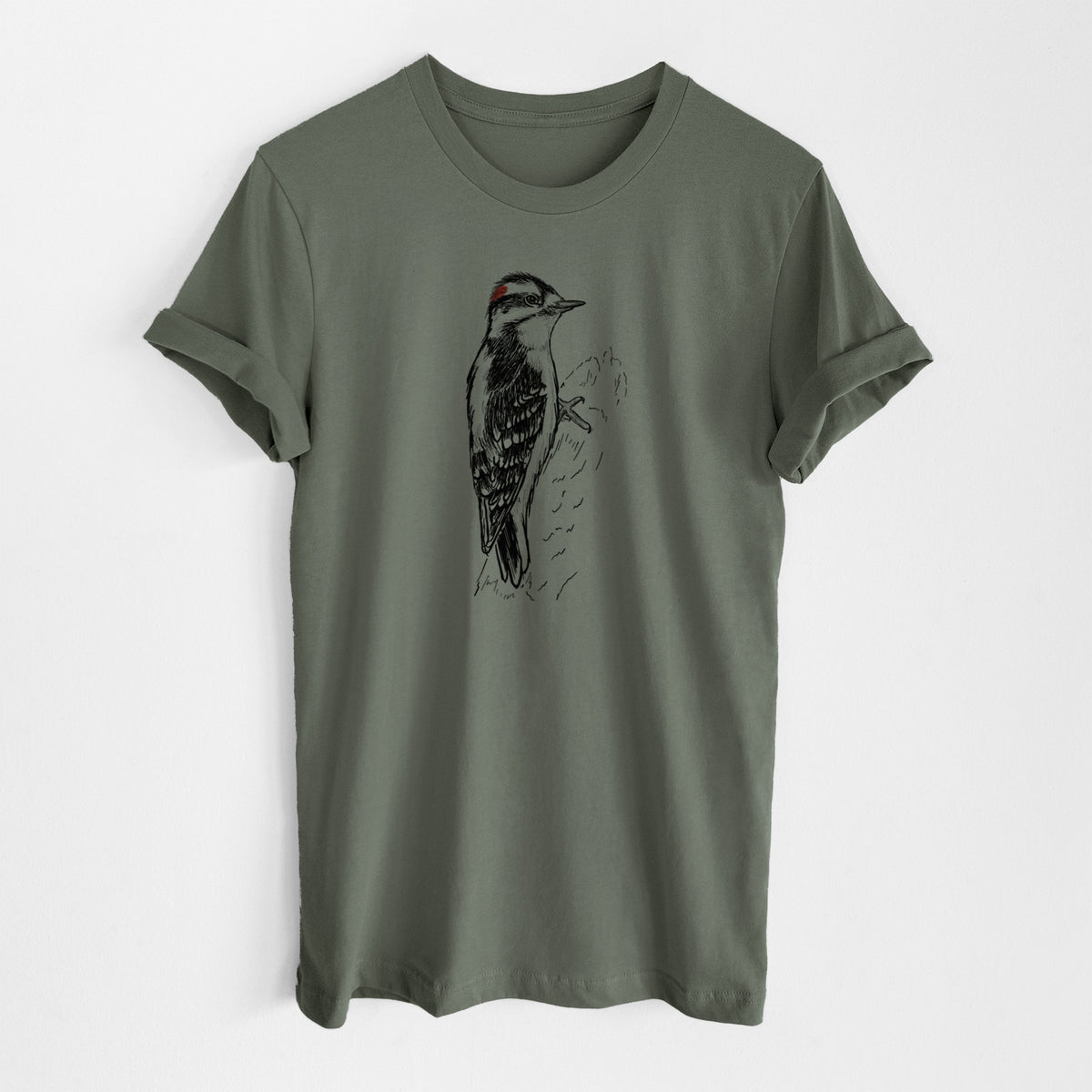Military green lightweight cotton t-shirt laid flat, printed with a detailed black ink illustration of a downy woodpecker clinging to a tree trunk.