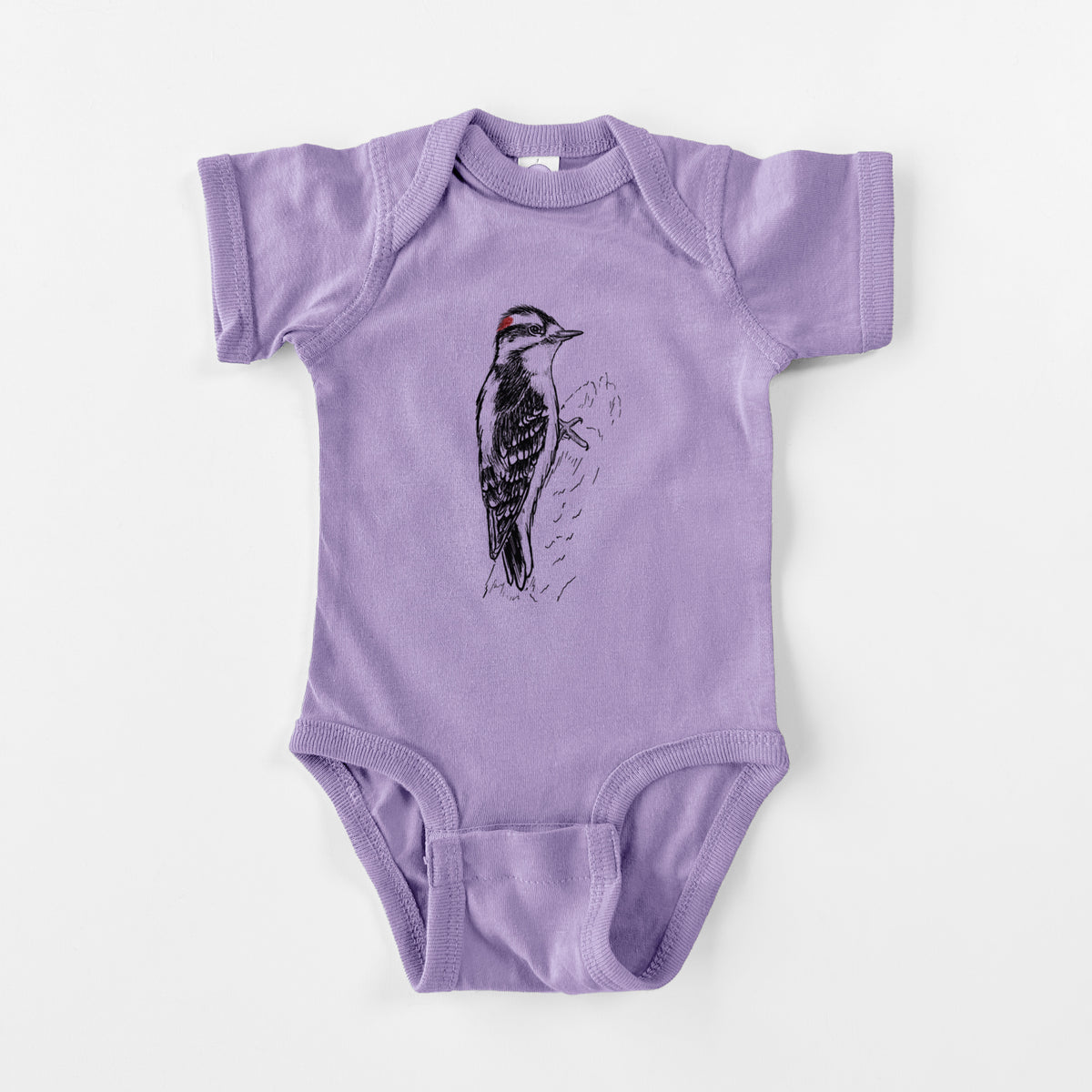 Lavender baby bodysuit laid flat, printed with a detailed black ink illustration of a downy woodpecker clinging to a tree trunk.