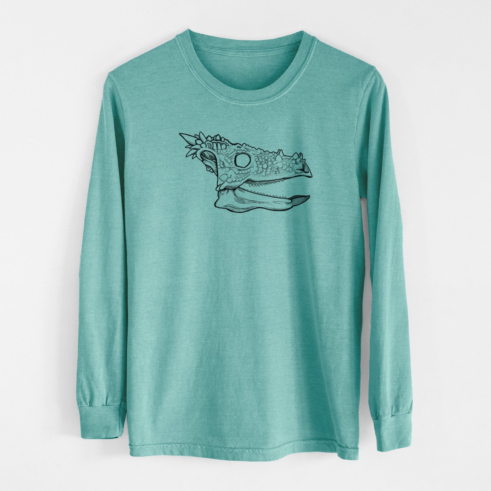 Reef green Comfort Colors long sleeve shirt laid flat, printed with a black ink illustration of a spiky Dracorex dinosaur skull.