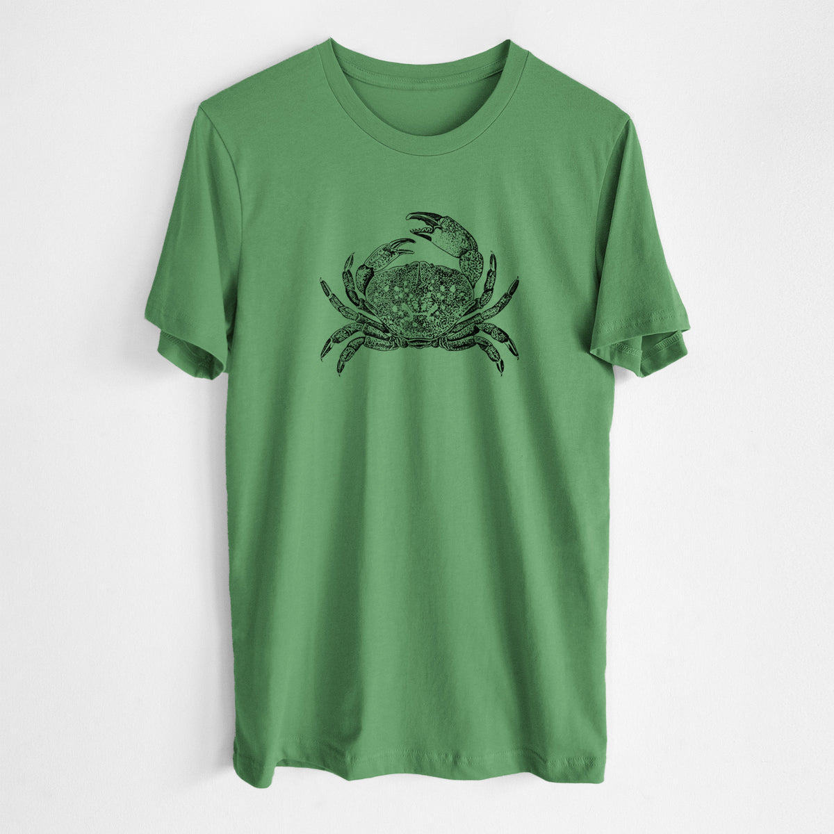 Leaf green lightweight cotton t-shirt laid flat, printed with a detailed black ink illustration of a Dungeness crab with claws raised, seen from above.