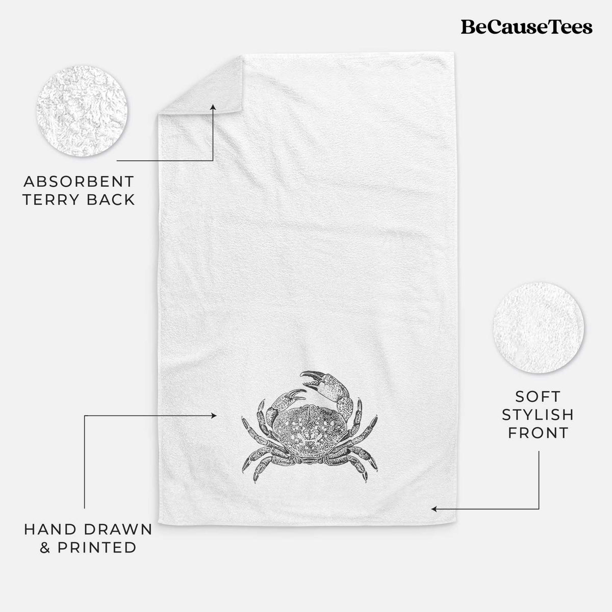 White hand towel printed with a detailed black ink illustration of a Dungeness crab with claws raised, seen from above.
