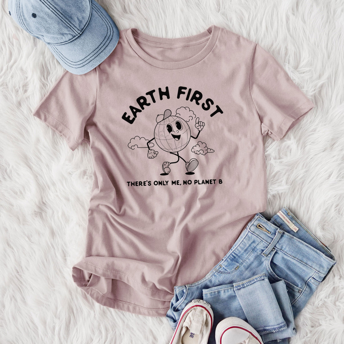 Women's relaxed fit cotton t-shirt printed with a cheerful cartoon Earth running, with the words Earth First and There's Only Me, No Planet B, styled flat on a white faux fur rug with jeans.