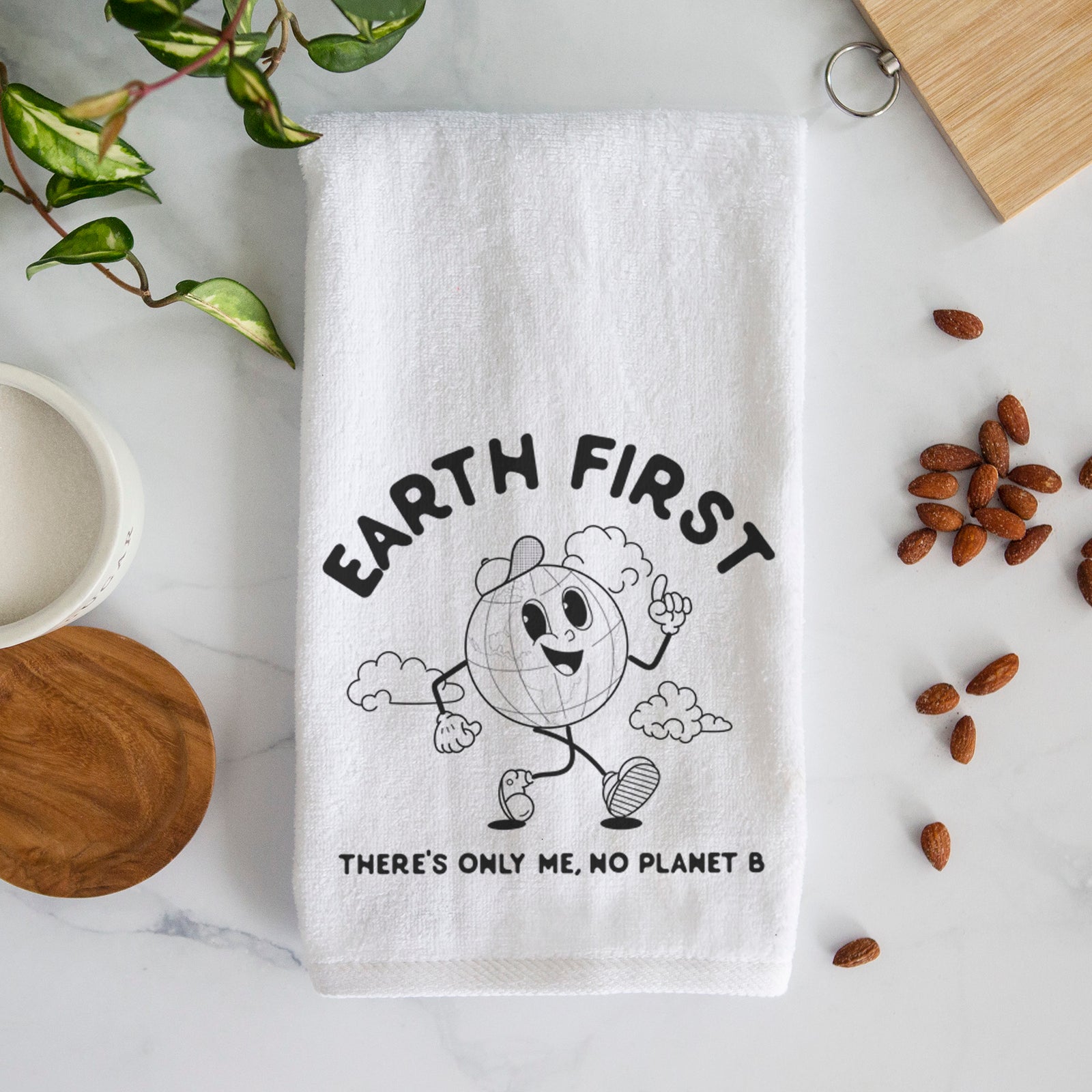 White hand towel printed with a cheerful cartoon Earth running, with the words Earth First and There's Only Me, No Planet B.