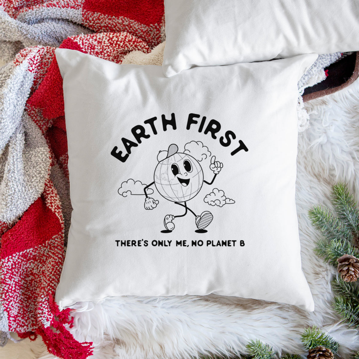White pillow cover printed with a cheerful cartoon Earth running, with the words Earth First and There's Only Me, No Planet B, on a woven chair.
