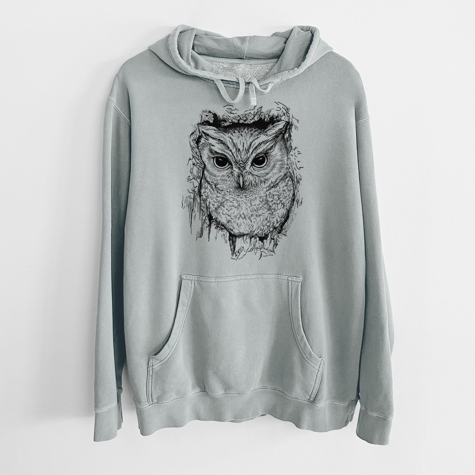 Sage green pigment dyed hoodie laid flat, printed with a detailed black ink portrait of an eastern screech owl with its ear tufts raised.