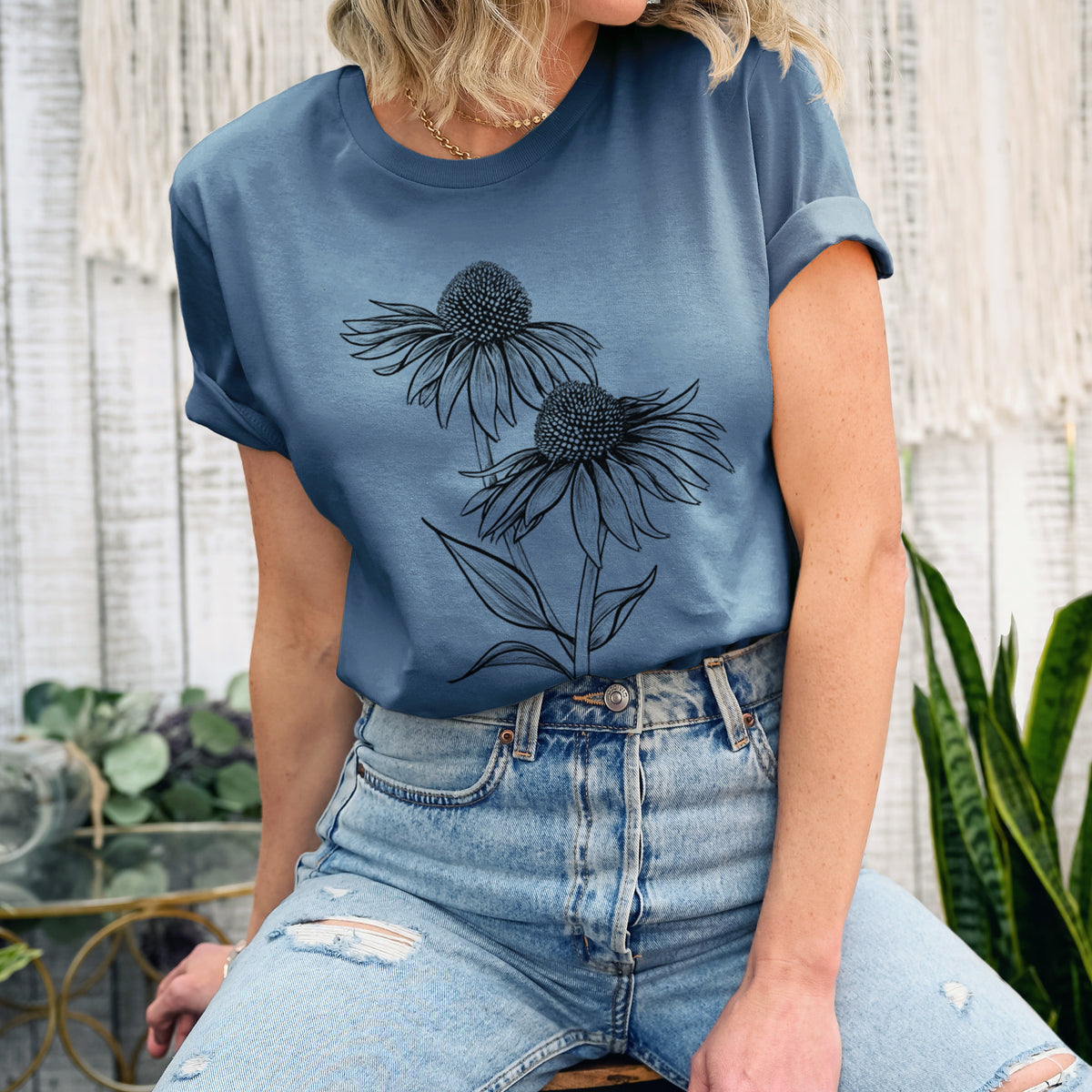 Woman wearing a steel blue lightweight cotton t-shirt printed with a black ink line drawing of two coneflowers on tall stems.