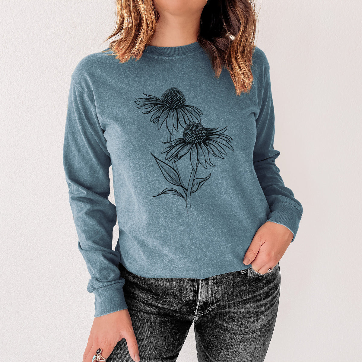 Steel blue Comfort Colors long sleeve shirt printed with a black ink line drawing of two coneflowers on tall stems, shown in a lifestyle photo.