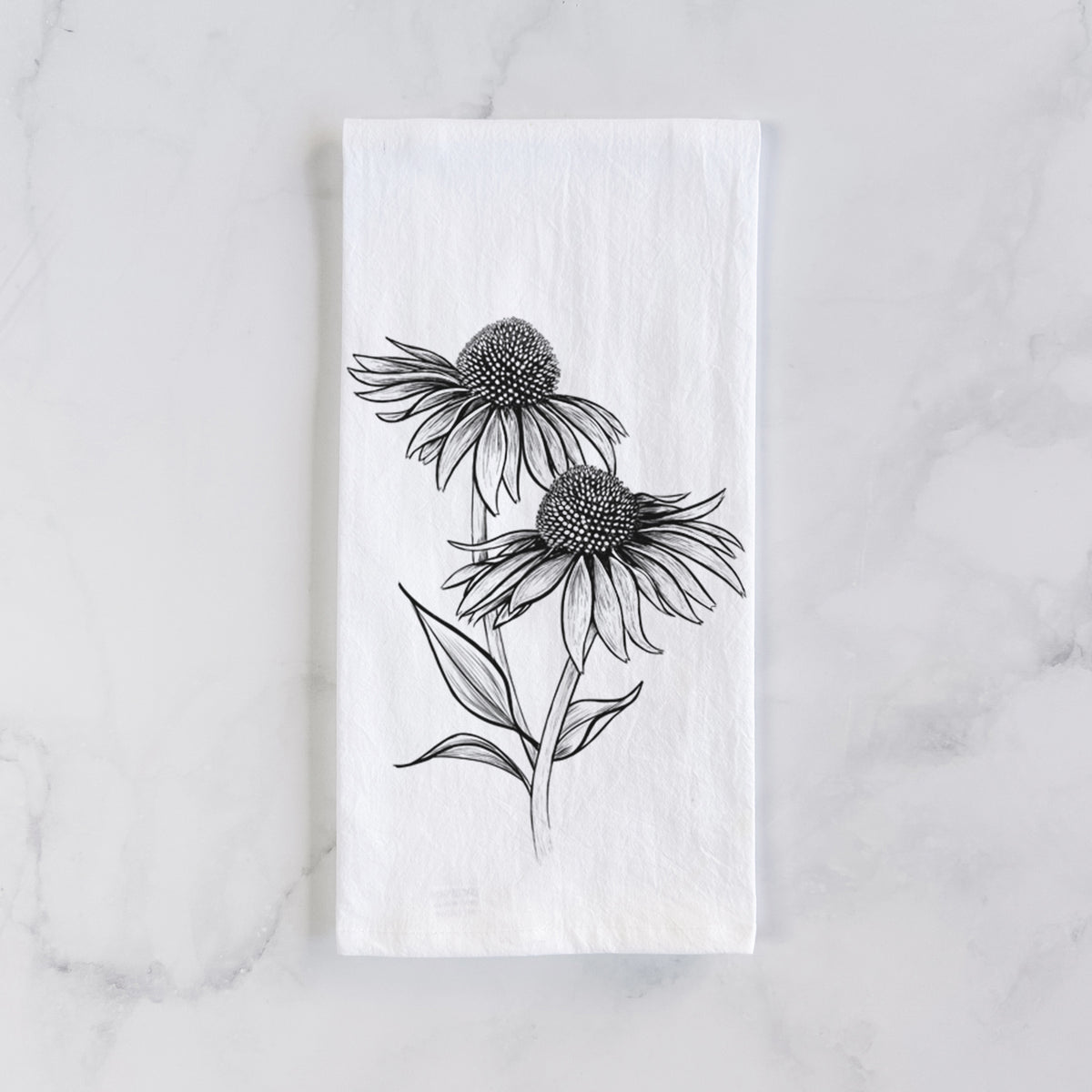 White cotton tea towel laid flat on marble, printed with a black ink line drawing of two coneflowers on tall stems.