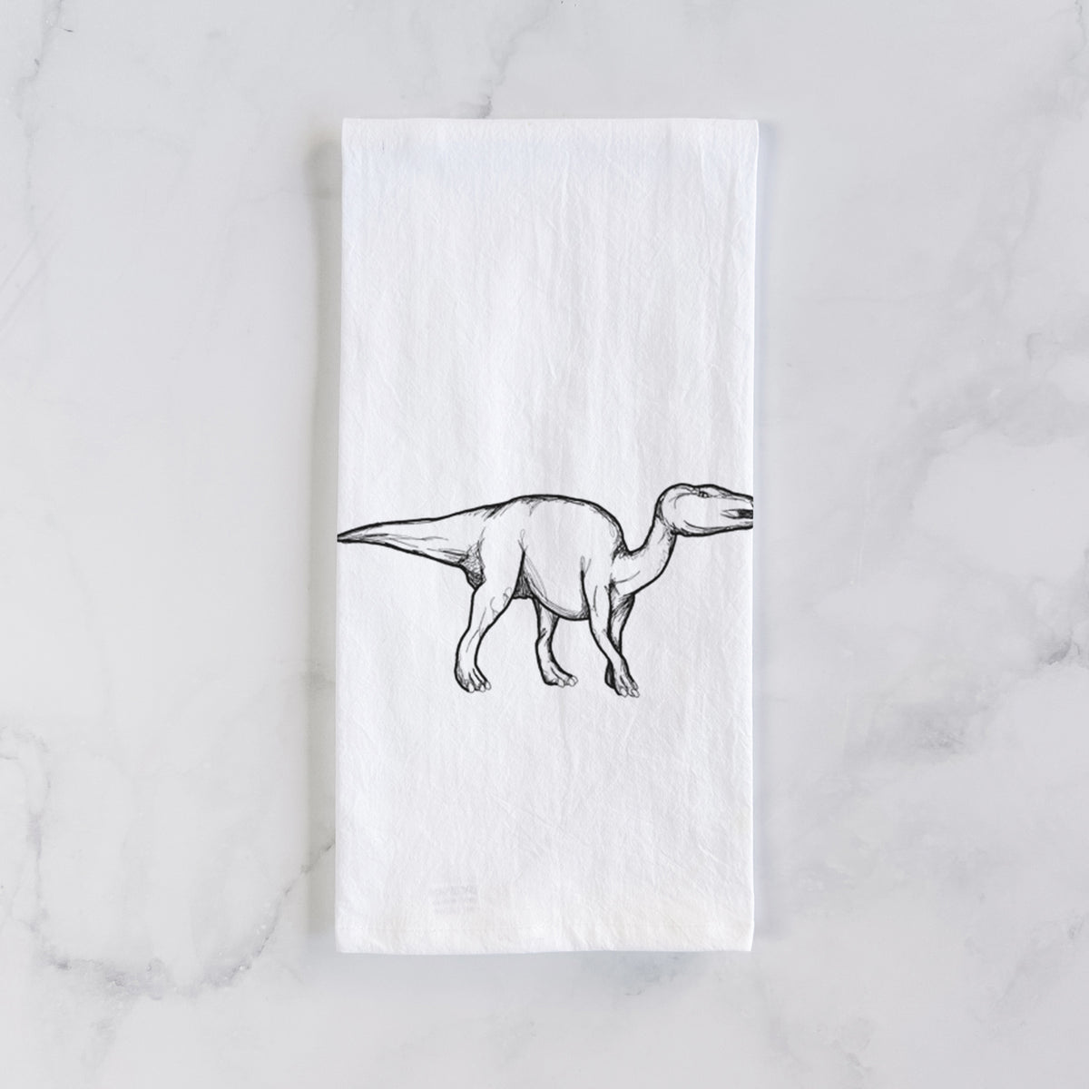 White cotton tea towel laid flat on marble, printed with a black ink illustration of an Edmontosaurus walking.