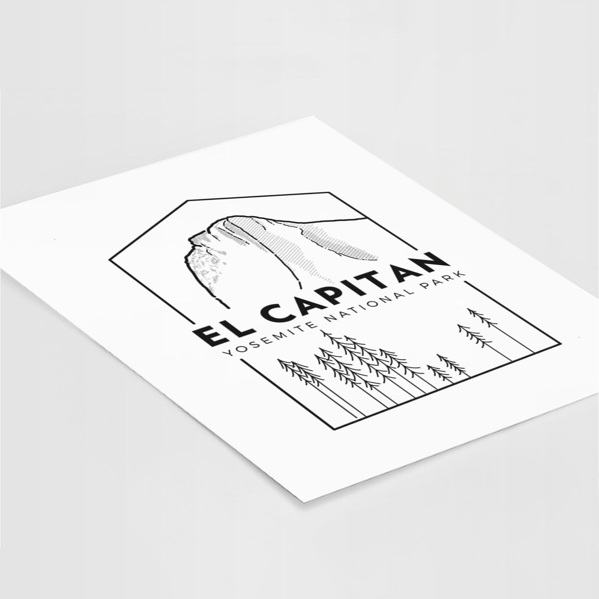 Art print of a black line art badge of El Capitan rising above a pine forest, with the words El Capitan, Yosemite National Park, lying at an angle on a white surface.