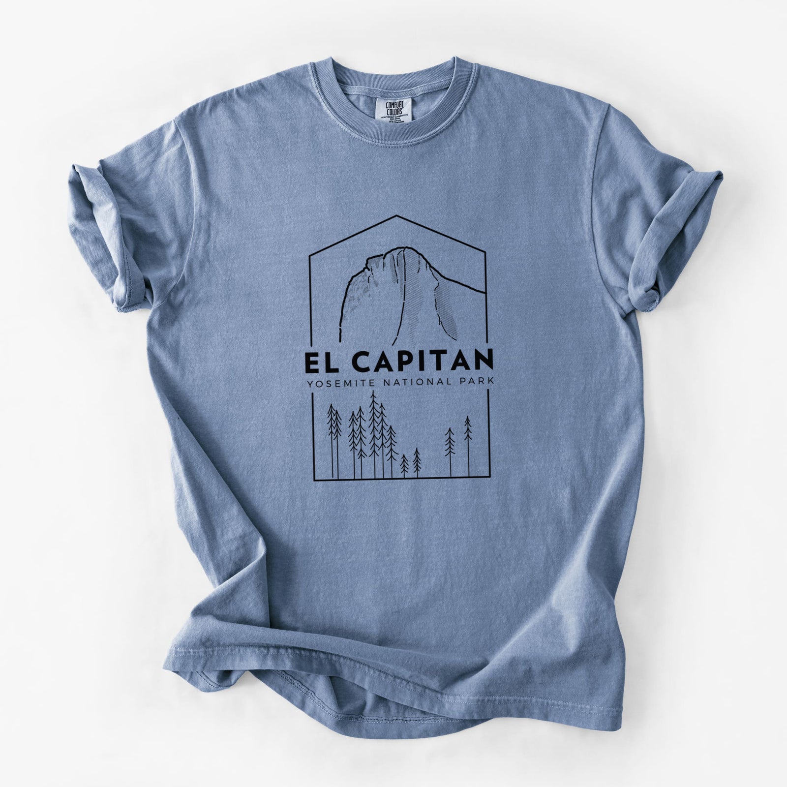 Blue jean Comfort Colors t-shirt laid flat, printed with a black line art badge of El Capitan rising above a pine forest, with the words El Capitan, Yosemite National Park.