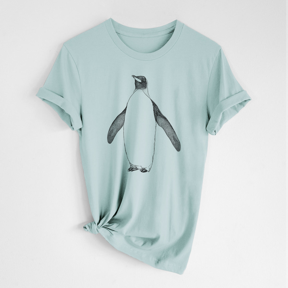 Dusty blue lightweight cotton t-shirt laid flat with the sleeves rolled, printed with a black ink illustration of an emperor penguin standing.