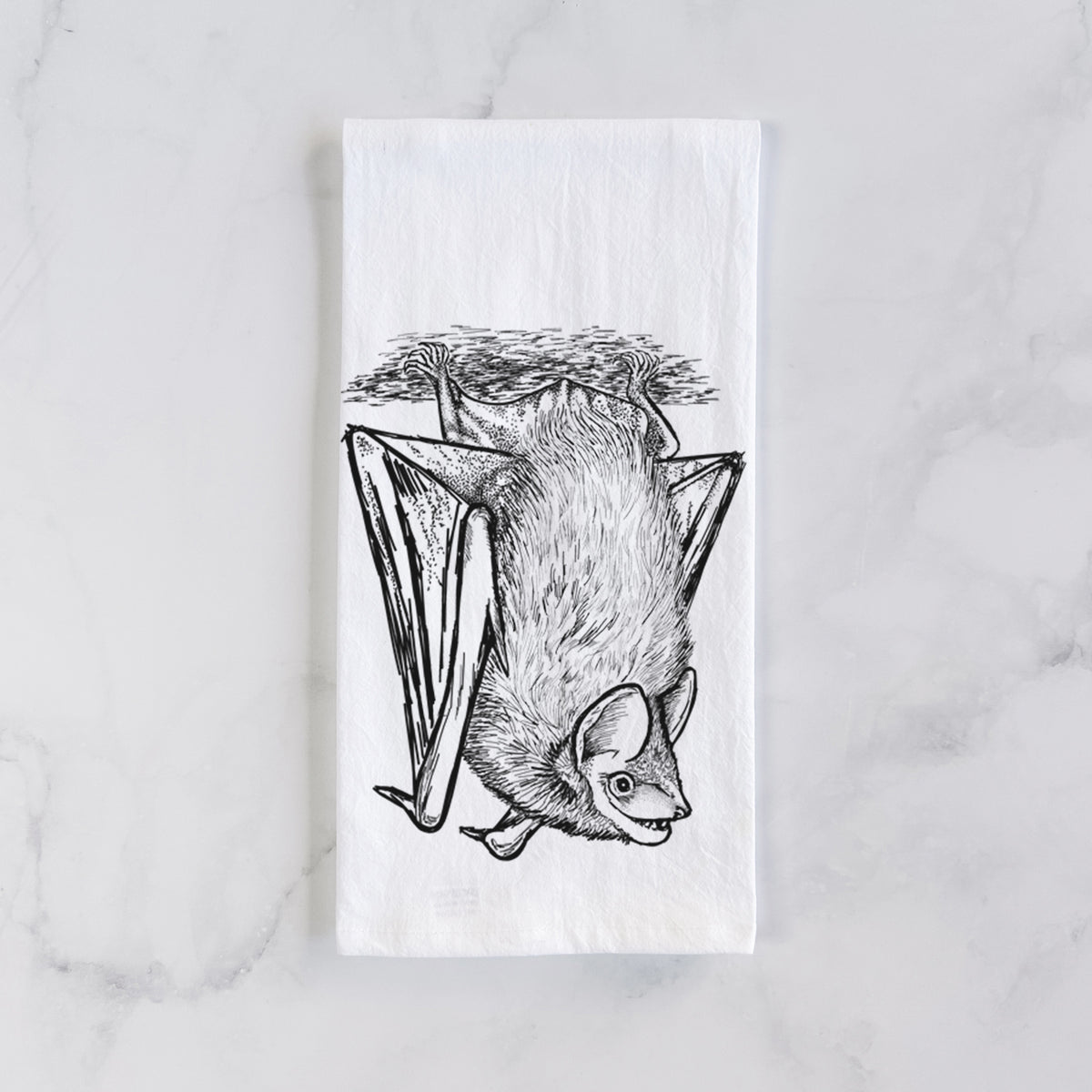 White cotton tea towel laid flat on marble, printed with a detailed black ink illustration of a big brown bat hanging upside down.