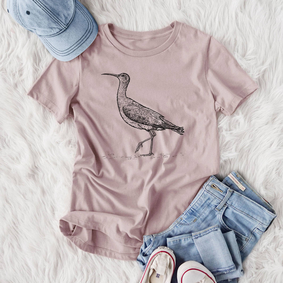 Women's relaxed fit cotton t-shirt printed with a detailed black ink illustration of an Eskimo curlew with its long curved bill, walking, styled flat on a white faux fur rug with jeans.