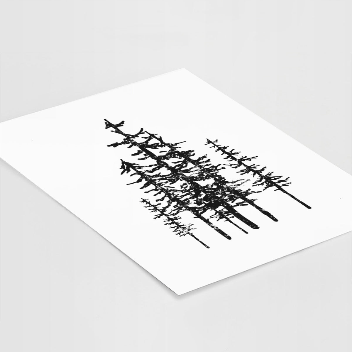 Art print of a black ink illustration of a cluster of evergreen trees of varying heights, lying at an angle on a white surface.