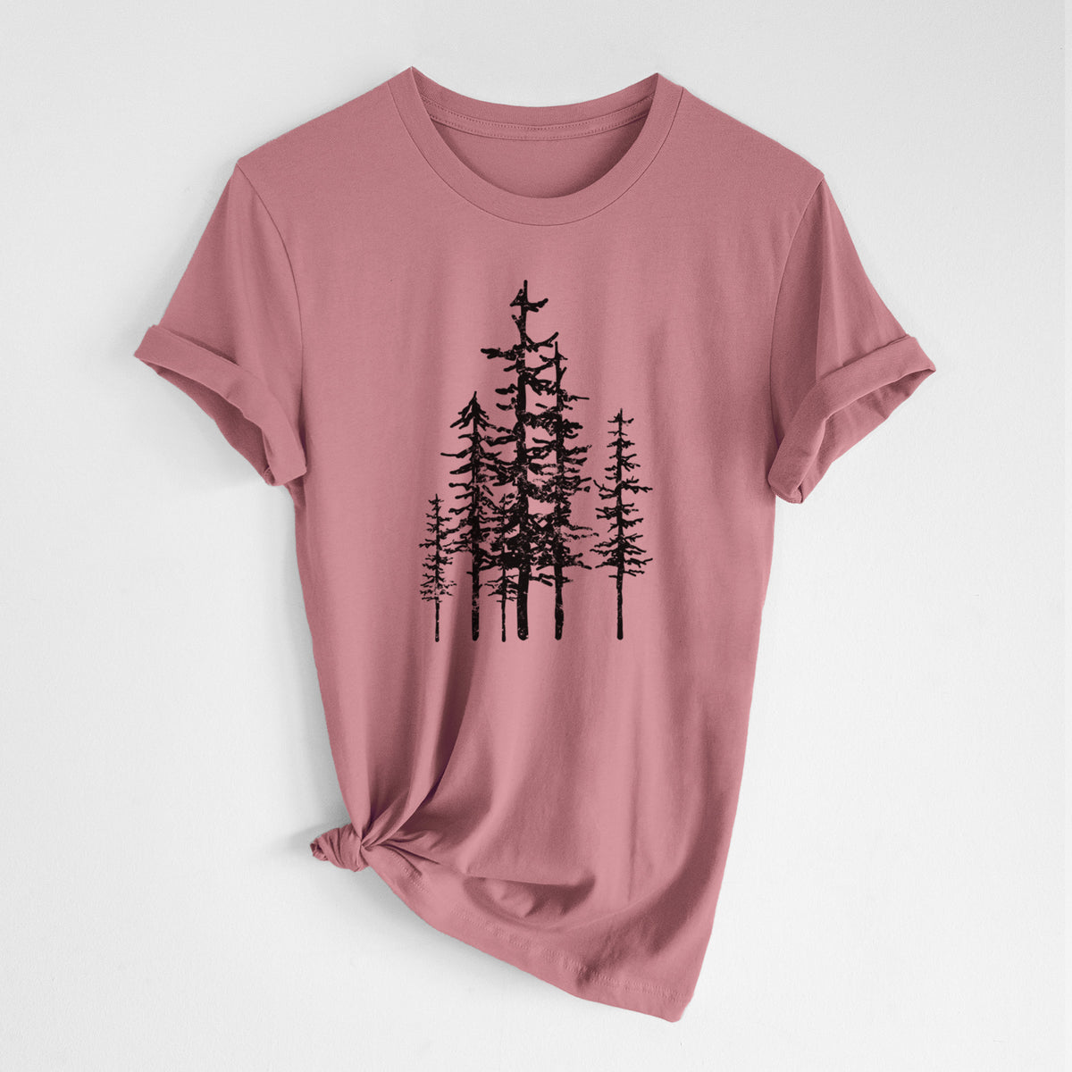 Mauve pink lightweight cotton t-shirt laid flat with the sleeves rolled, printed with a black ink illustration of a cluster of evergreen trees of varying heights.