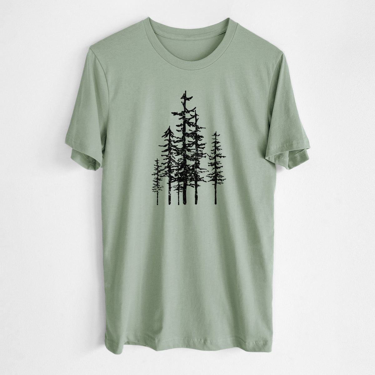 Sage green lightweight cotton t-shirt laid flat, printed with a black ink illustration of a cluster of evergreen trees of varying heights.