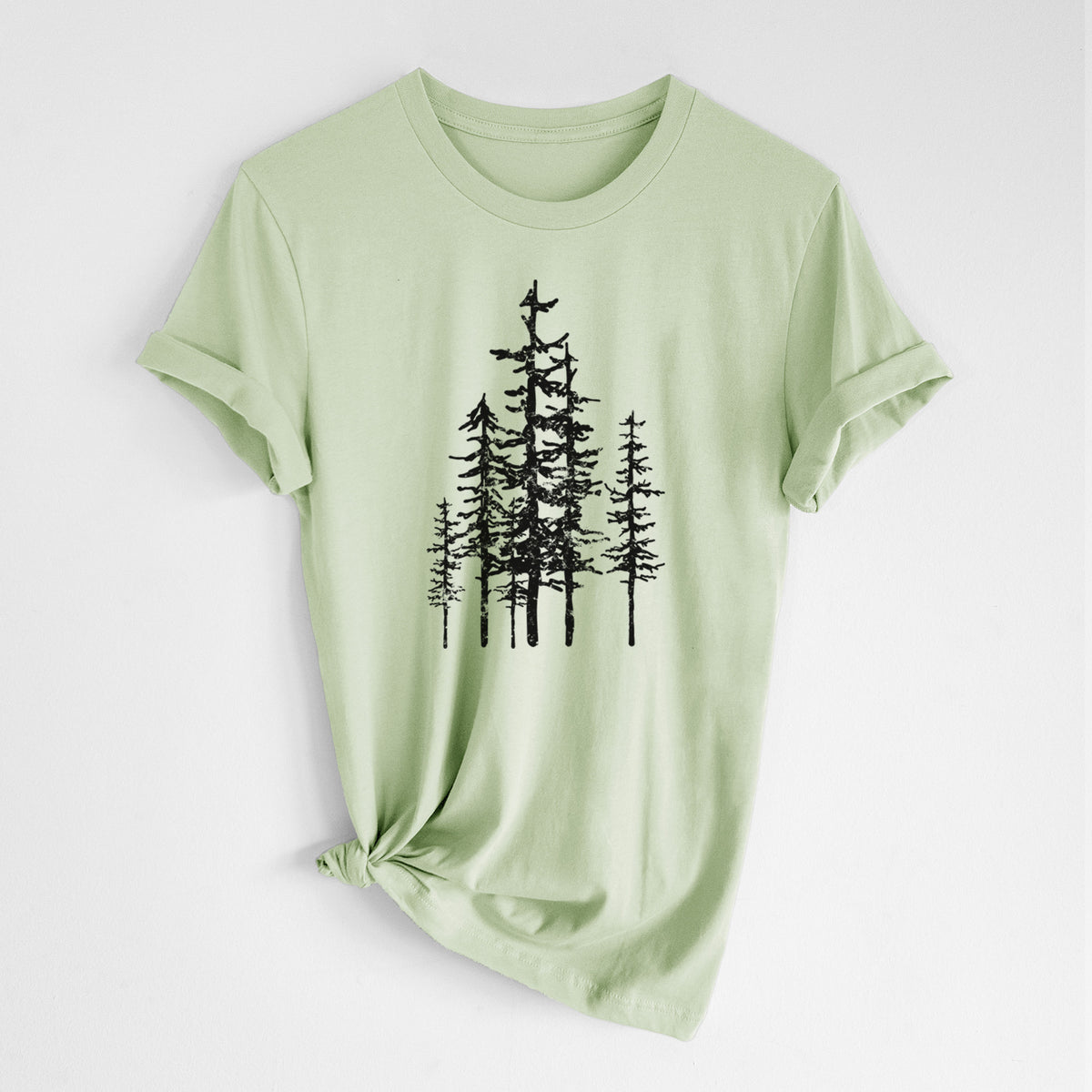 Spring green lightweight cotton t-shirt laid flat with the sleeves rolled, printed with a black ink illustration of a cluster of evergreen trees of varying heights.