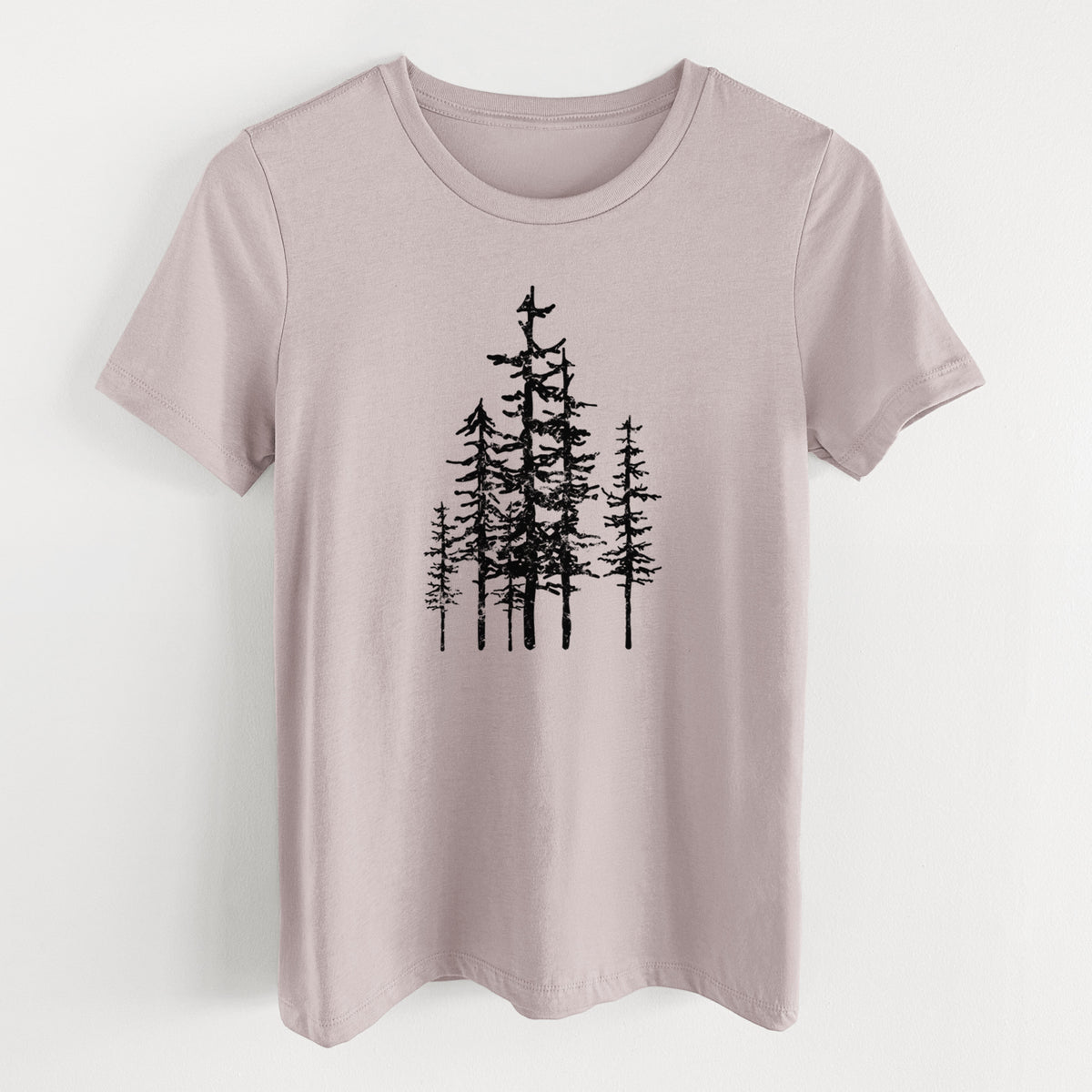 Pink gravel women's relaxed fit cotton t-shirt laid flat, printed with a black ink illustration of a cluster of evergreen trees of varying heights.