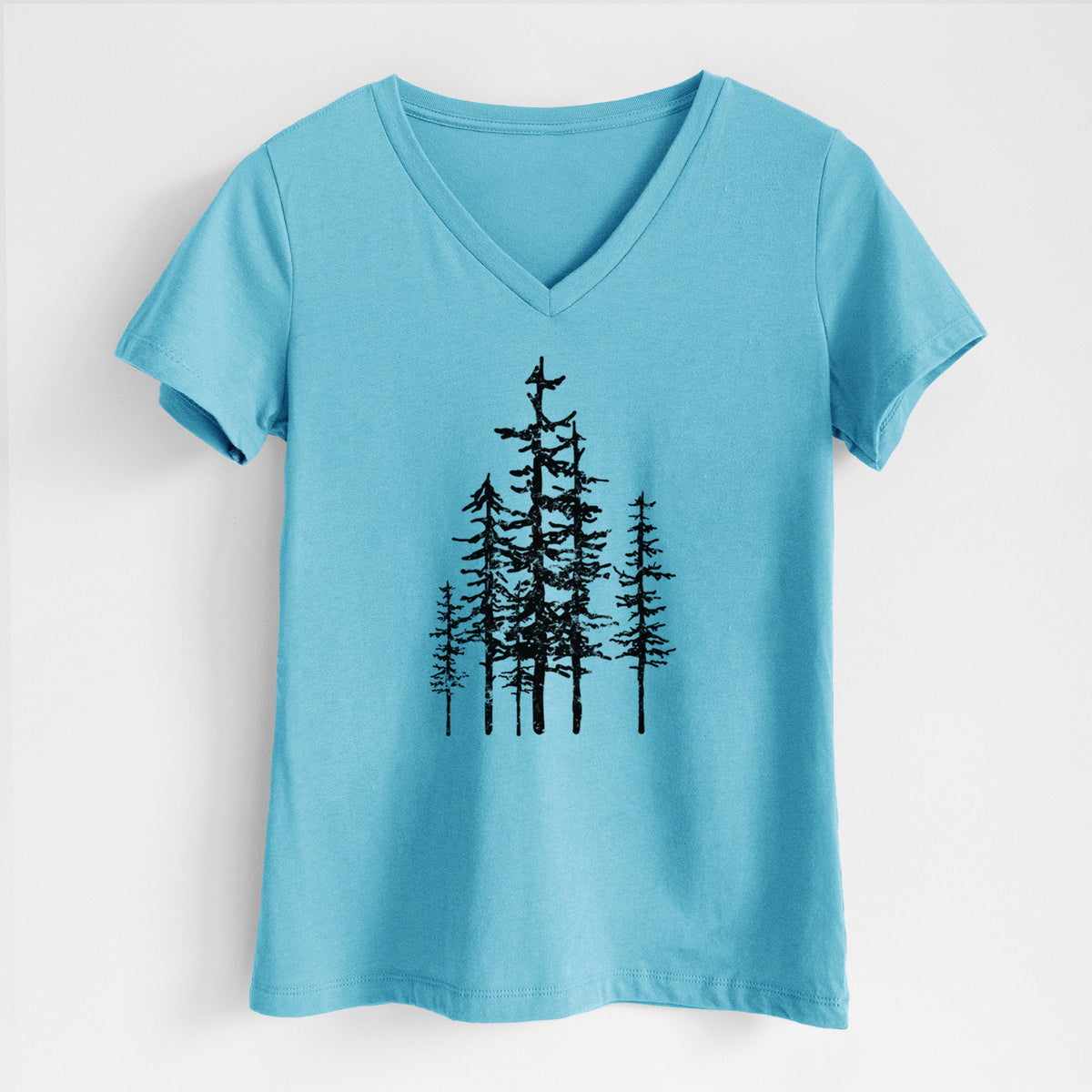 Turquoise women's relaxed fit cotton V-neck t-shirt laid flat, printed with a black ink illustration of a cluster of evergreen trees of varying heights.