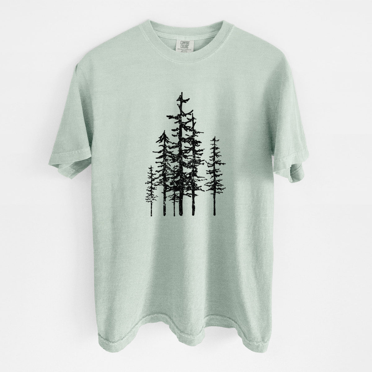 Bay green Comfort Colors t-shirt laid flat, printed with a black ink illustration of a cluster of evergreen trees of varying heights.