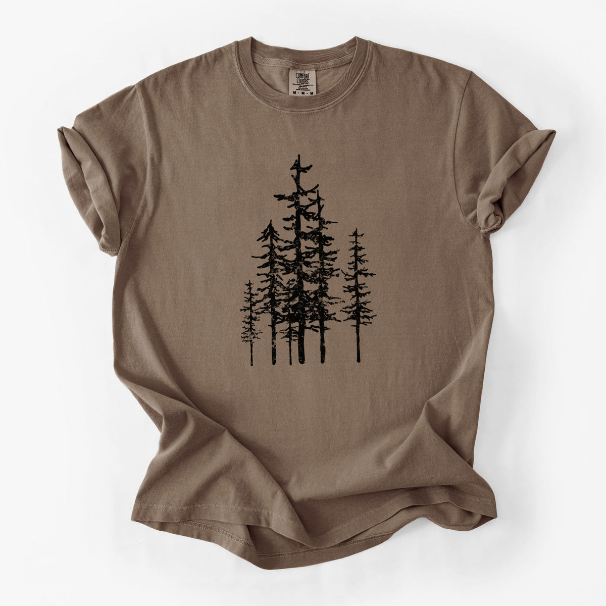 Espresso brown Comfort Colors t-shirt laid flat, printed with a black ink illustration of a cluster of evergreen trees of varying heights.