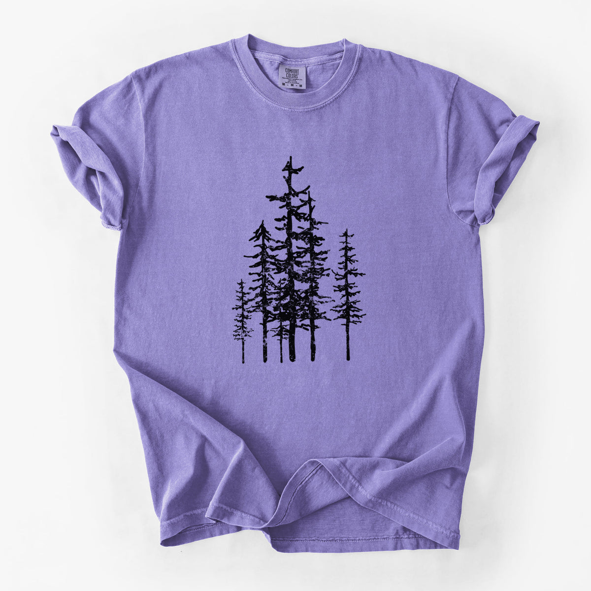 Violet purple Comfort Colors t-shirt laid flat, printed with a black ink illustration of a cluster of evergreen trees of varying heights.