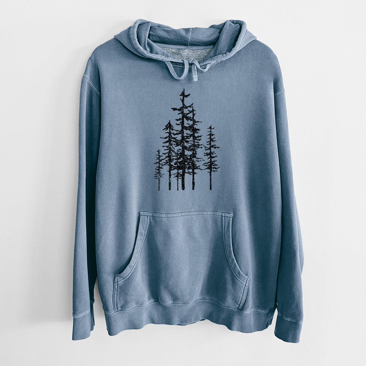 Slate blue pigment dyed hoodie laid flat, printed with a black ink illustration of a cluster of evergreen trees of varying heights.