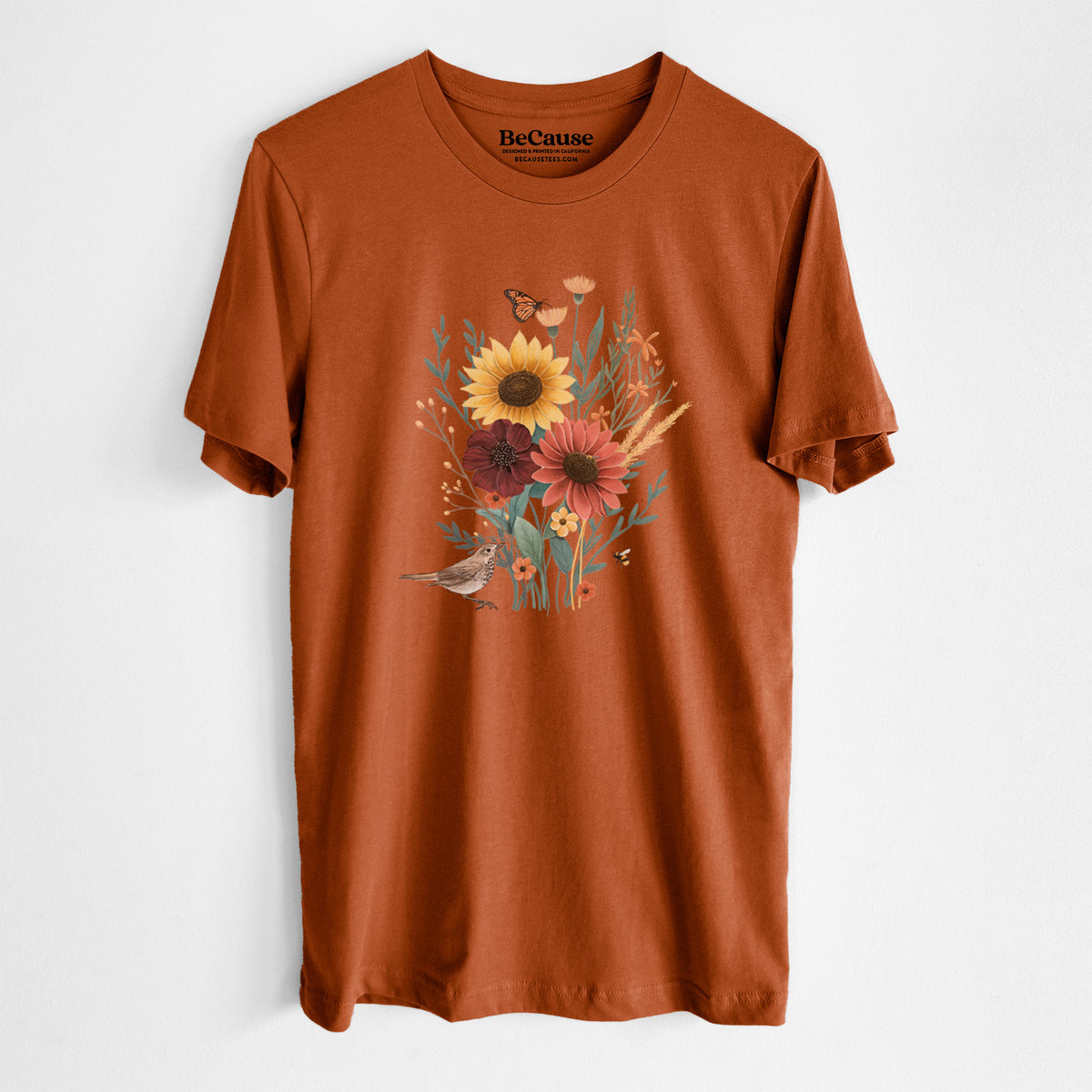 Autumn lightweight cotton t-shirt laid flat, printed with a full-color bouquet of sunflowers, red flowers and wildflowers with butterflies and a small bird.