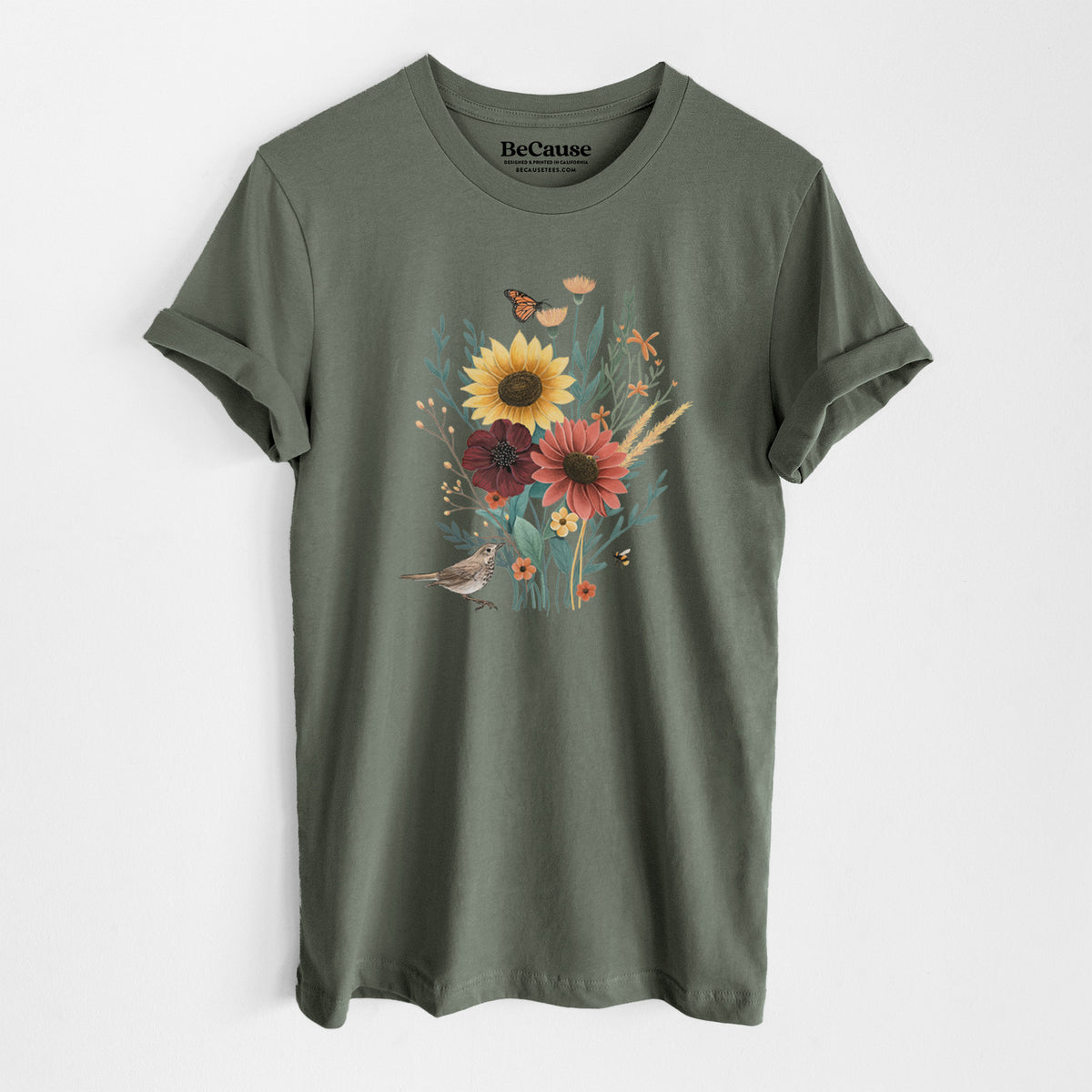 Military green lightweight cotton t-shirt laid flat, printed with a full-color bouquet of sunflowers, red flowers and wildflowers with butterflies and a small bird.