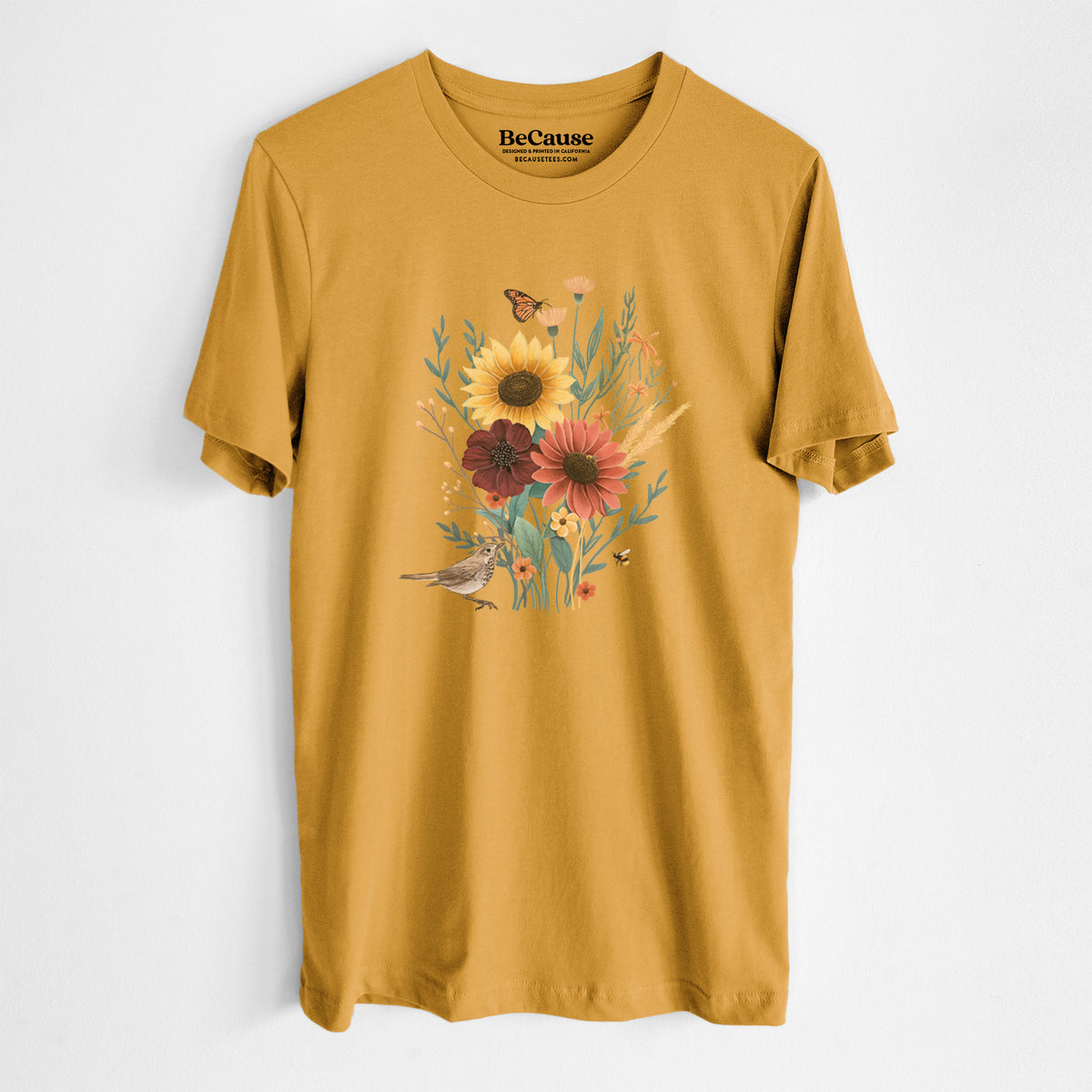 Mustard yellow lightweight cotton t-shirt laid flat, printed with a full-color bouquet of sunflowers, red flowers and wildflowers with butterflies and a small bird.