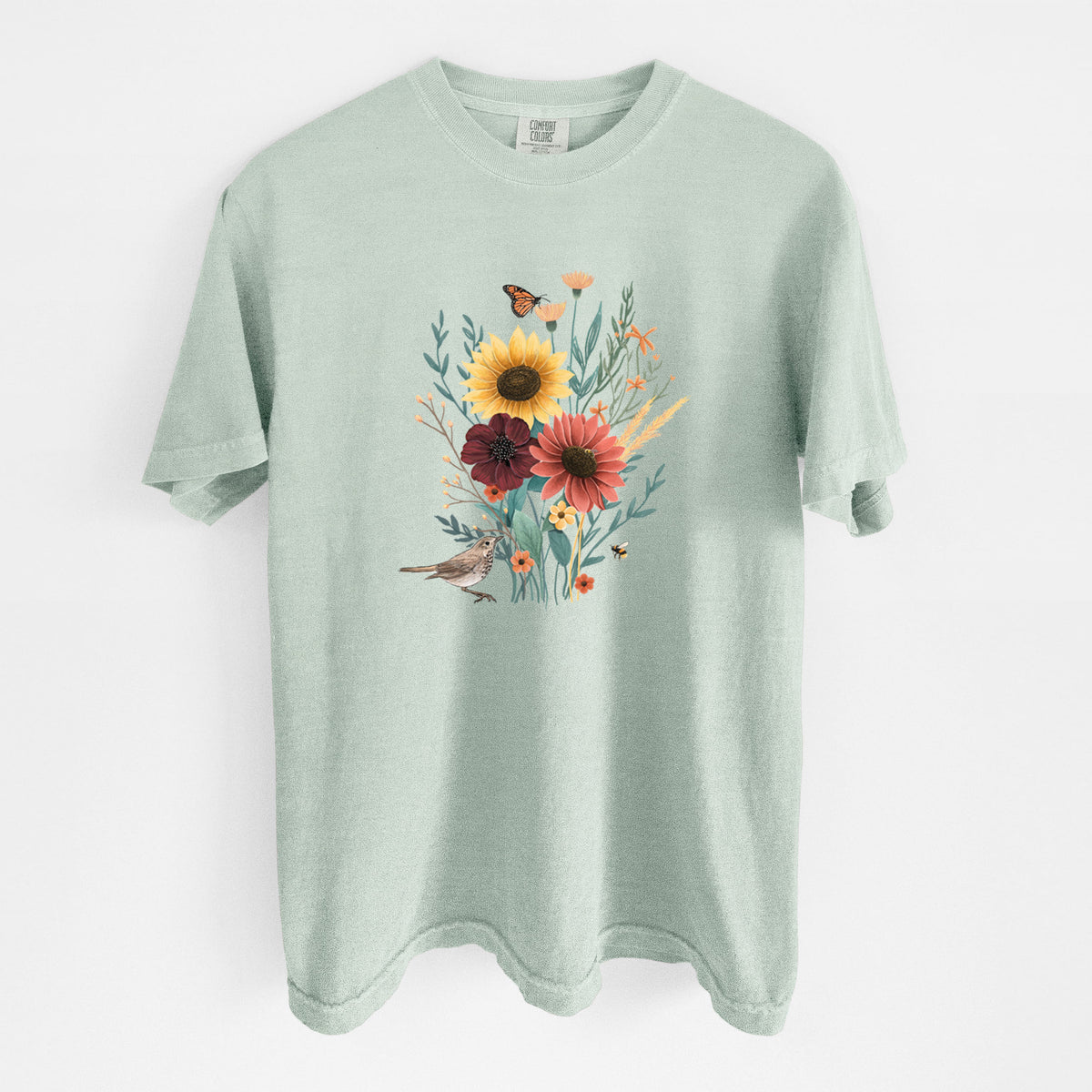 Bay green Comfort Colors t-shirt laid flat, printed with a full-color bouquet of sunflowers, red flowers and wildflowers with butterflies and a small bird.