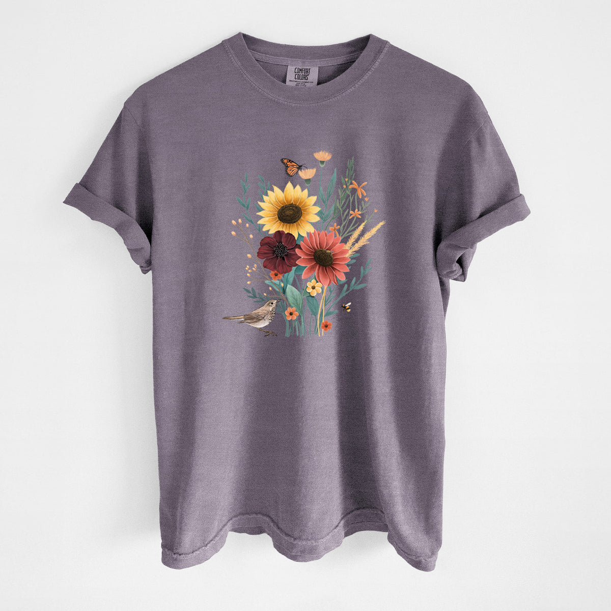 Wine red Comfort Colors t-shirt laid flat, printed with a full-color bouquet of sunflowers, red flowers and wildflowers with butterflies and a small bird.