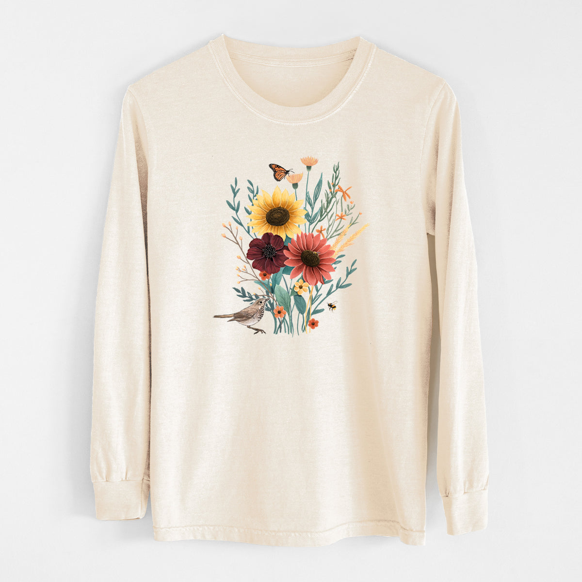Ivory Comfort Colors long sleeve shirt laid flat, printed with a full-color bouquet of sunflowers, red flowers and wildflowers with butterflies and a small bird.