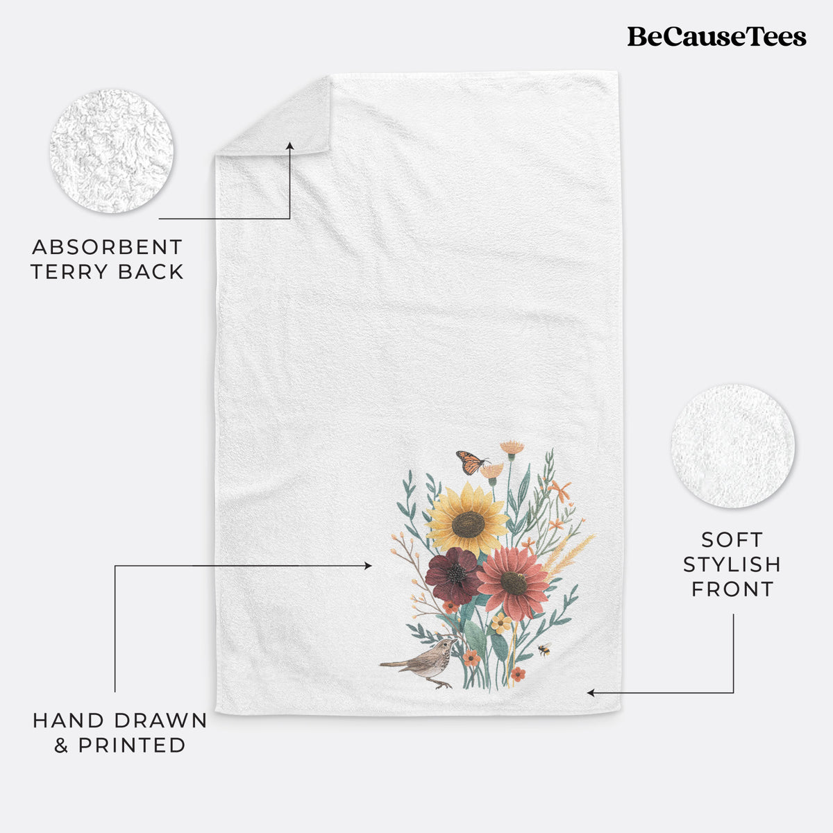 White hand towel printed with a full-color bouquet of sunflowers, red flowers and wildflowers with butterflies and a small bird.
