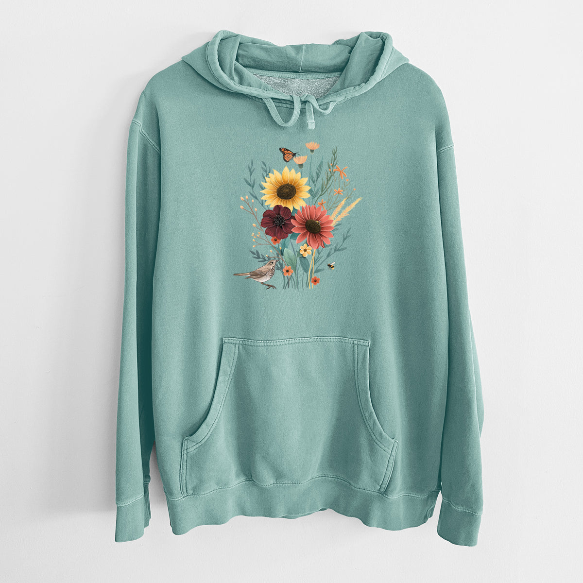 Mint green pigment dyed hoodie laid flat, printed with a full-color bouquet of sunflowers, red flowers and wildflowers with butterflies and a small bird.