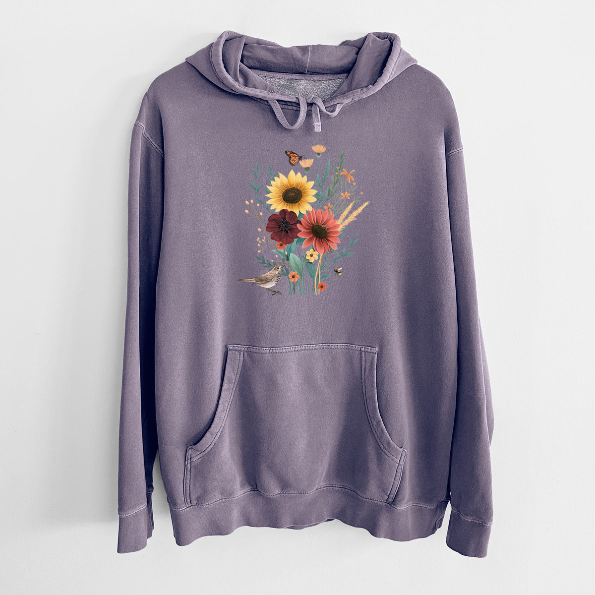 Plum purple pigment dyed hoodie laid flat, printed with a full-color bouquet of sunflowers, red flowers and wildflowers with butterflies and a small bird.