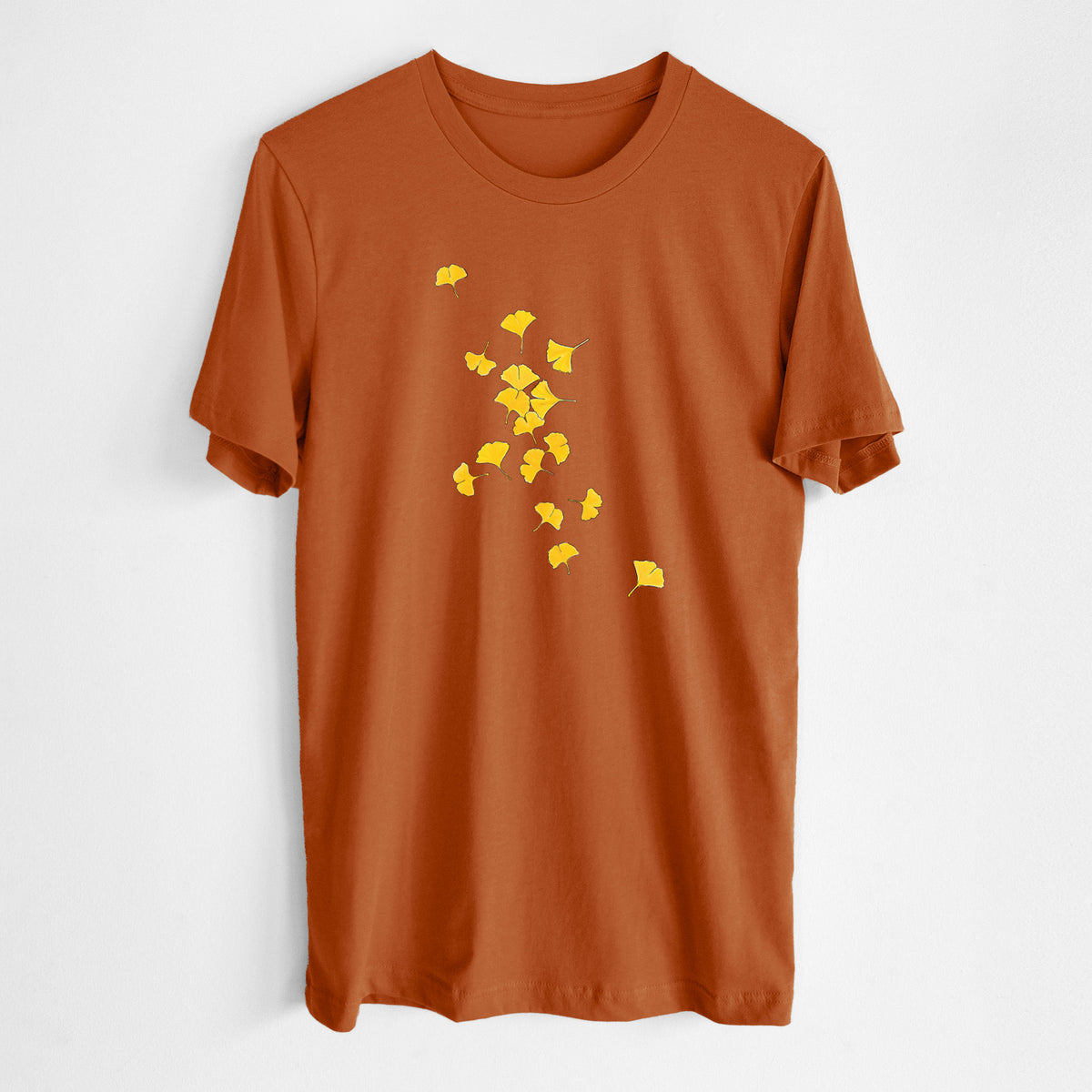 Autumn lightweight cotton t-shirt laid flat, printed with a scatter of bright yellow fan-shaped ginkgo leaves falling.