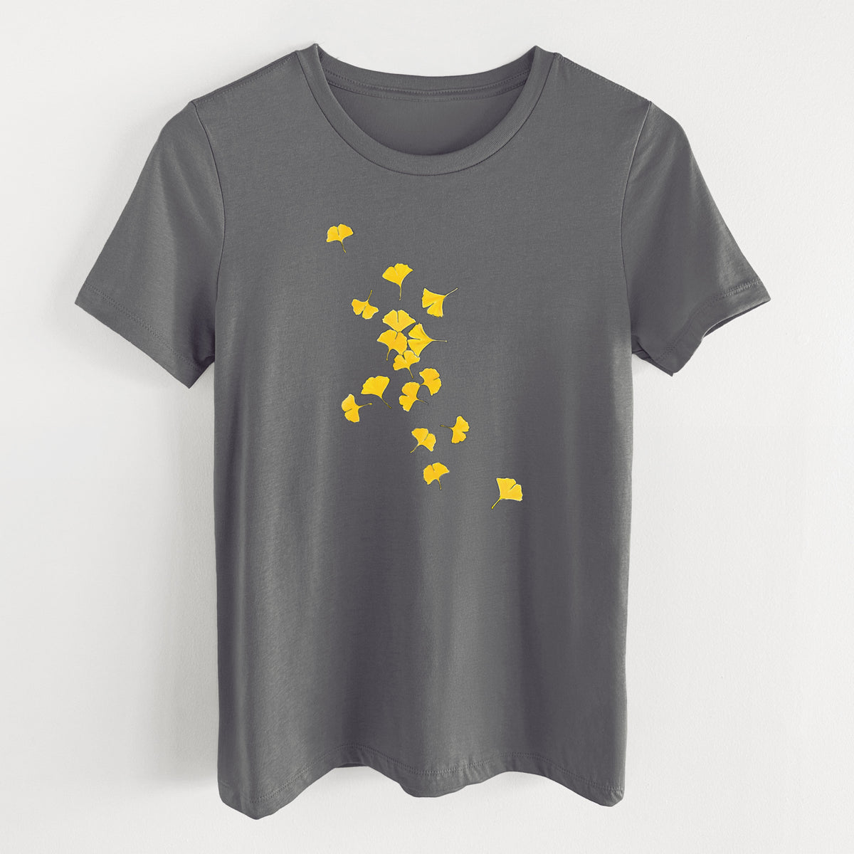Asphalt women's relaxed fit cotton t-shirt laid flat, printed with a scatter of bright yellow fan-shaped ginkgo leaves falling.