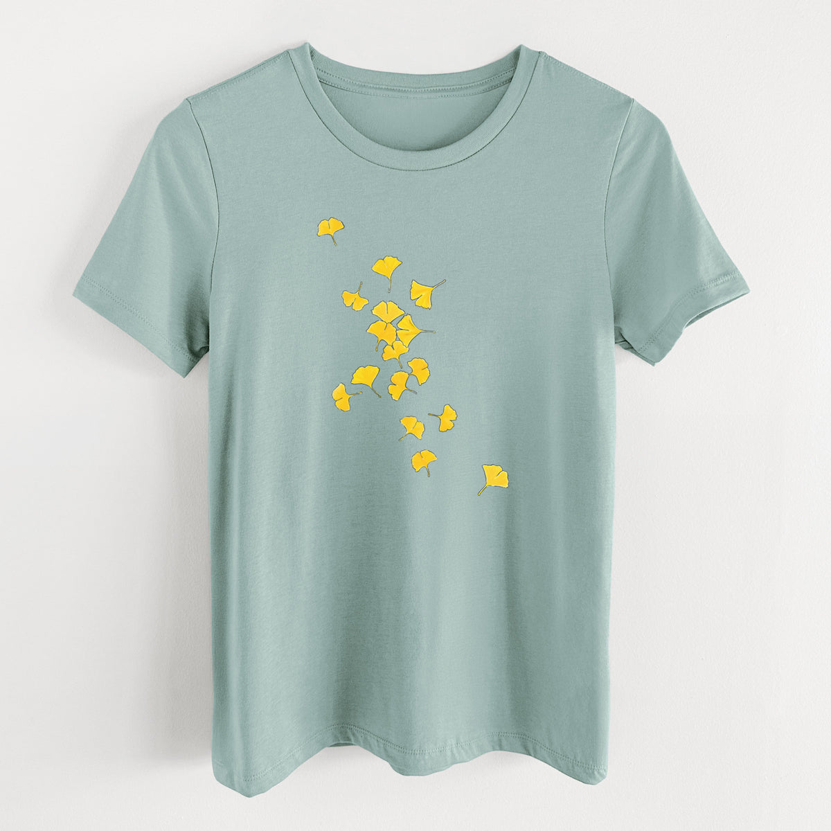 Dusty blue women's relaxed fit cotton t-shirt laid flat, printed with a scatter of bright yellow fan-shaped ginkgo leaves falling.