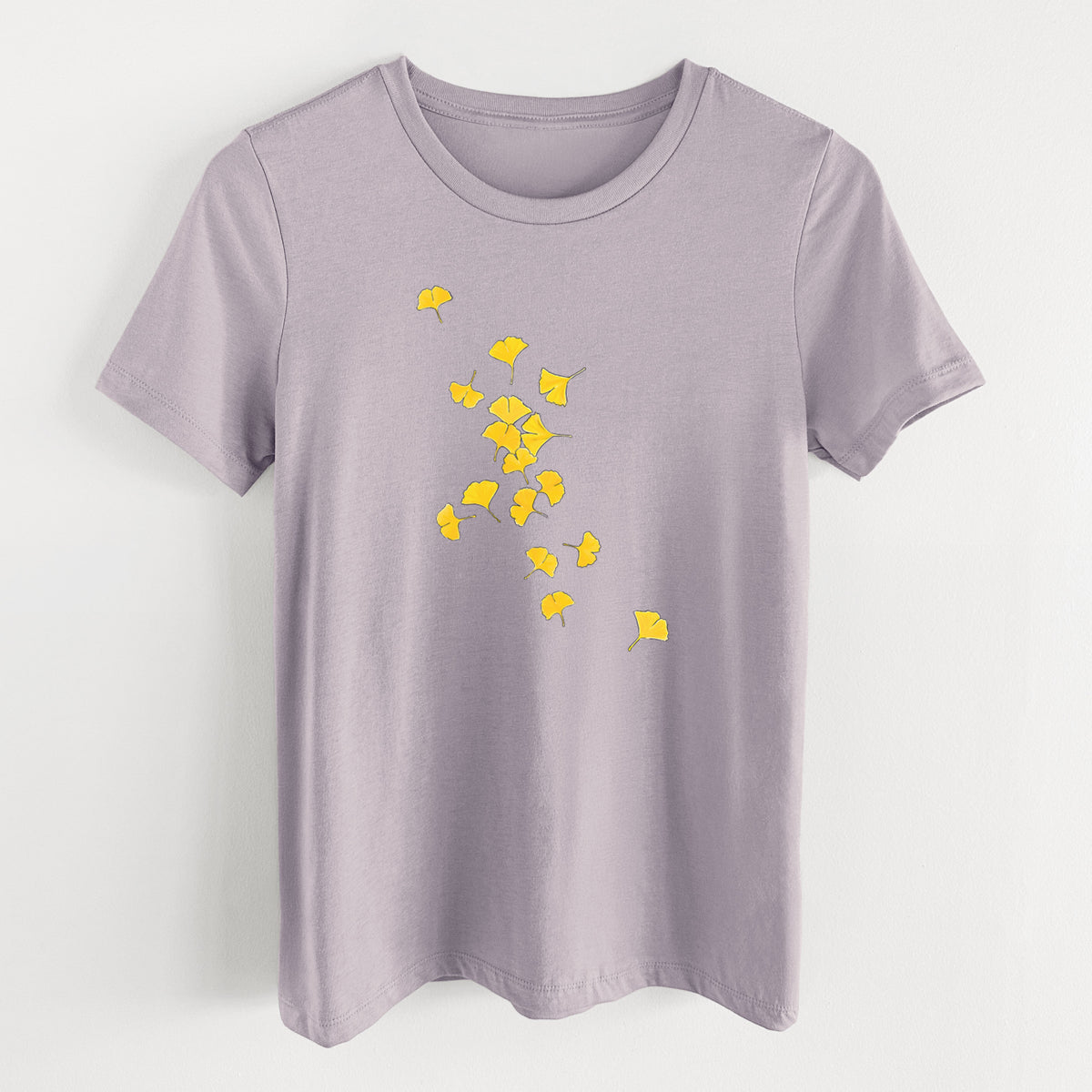 Light violet women's relaxed fit cotton t-shirt laid flat, printed with a scatter of bright yellow fan-shaped ginkgo leaves falling.