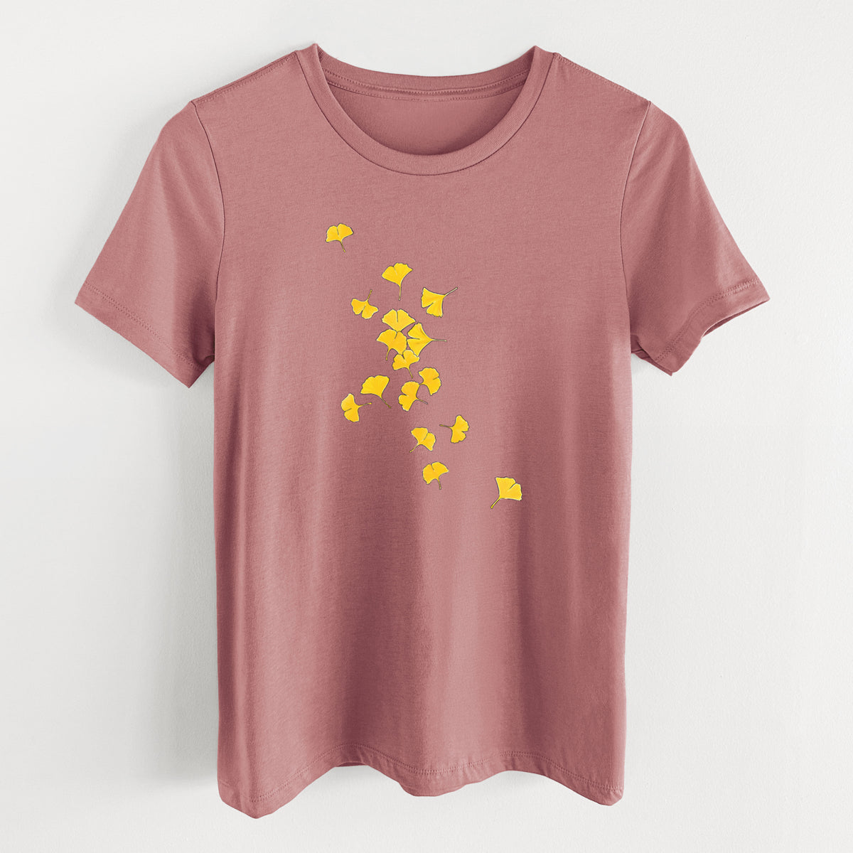 Mauve pink women's relaxed fit cotton t-shirt laid flat, printed with a scatter of bright yellow fan-shaped ginkgo leaves falling.