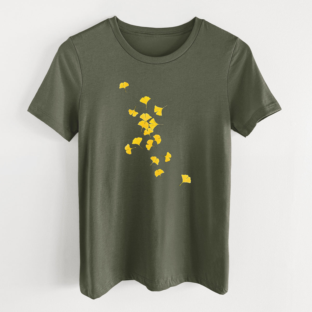 Military green women's relaxed fit cotton t-shirt laid flat, printed with a scatter of bright yellow fan-shaped ginkgo leaves falling.