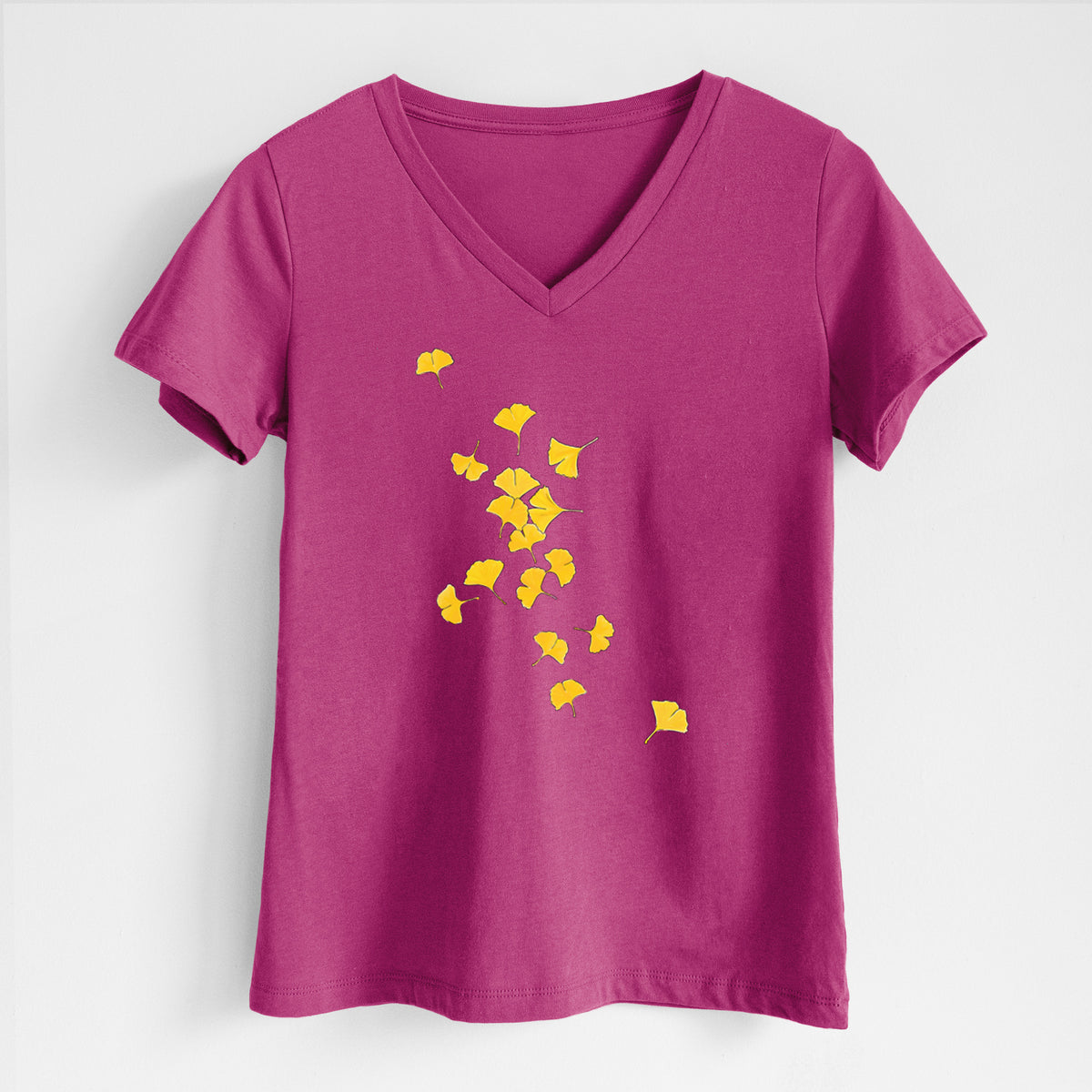 Berry pink women's relaxed fit cotton V-neck t-shirt laid flat, printed with a scatter of bright yellow fan-shaped ginkgo leaves falling.