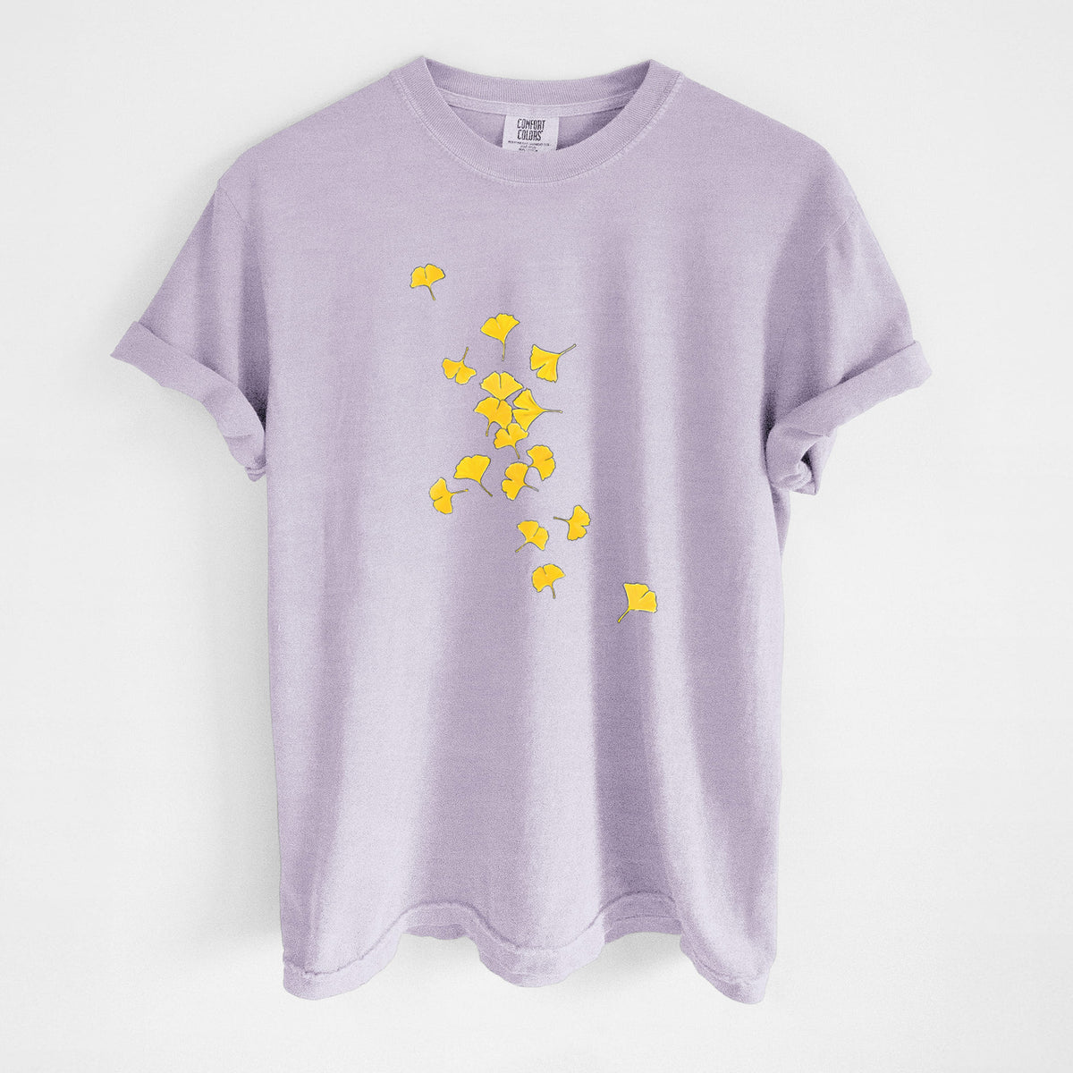Orchid purple Comfort Colors t-shirt laid flat, printed with a scatter of bright yellow fan-shaped ginkgo leaves falling.
