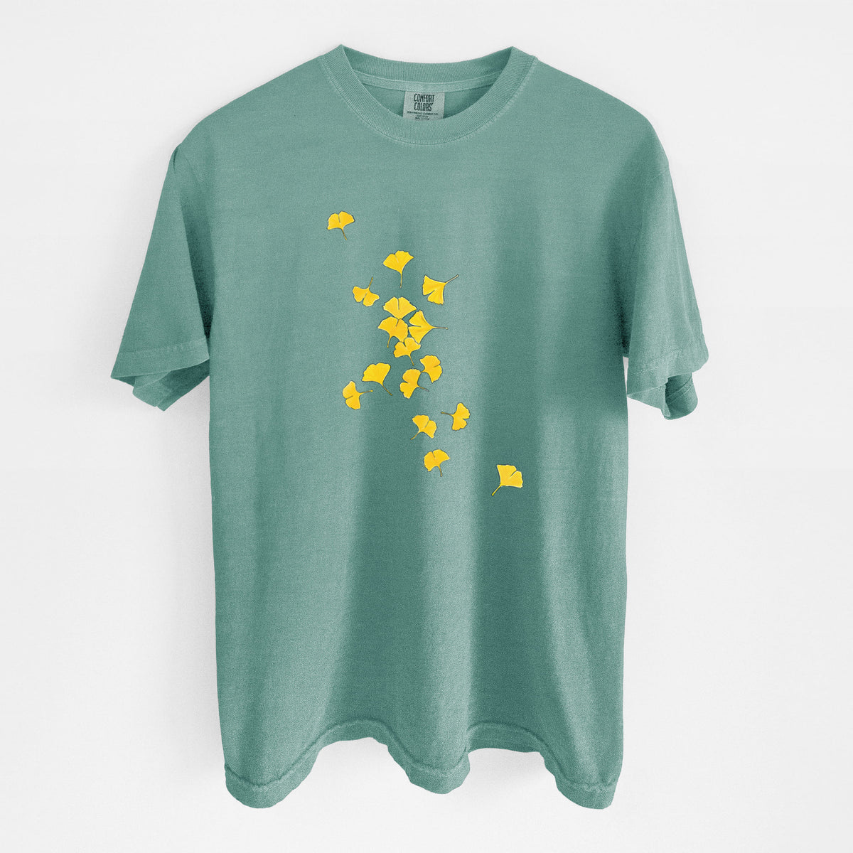 Reef green Comfort Colors t-shirt laid flat, printed with a scatter of bright yellow fan-shaped ginkgo leaves falling.