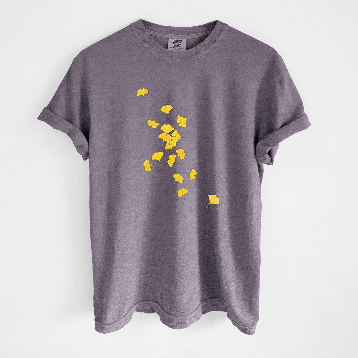 Wine red Comfort Colors t-shirt laid flat, printed with a scatter of bright yellow fan-shaped ginkgo leaves falling.