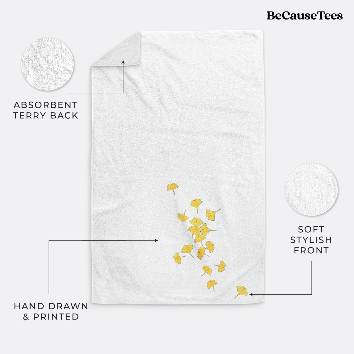 White hand towel printed with a scatter of bright yellow fan-shaped ginkgo leaves falling.