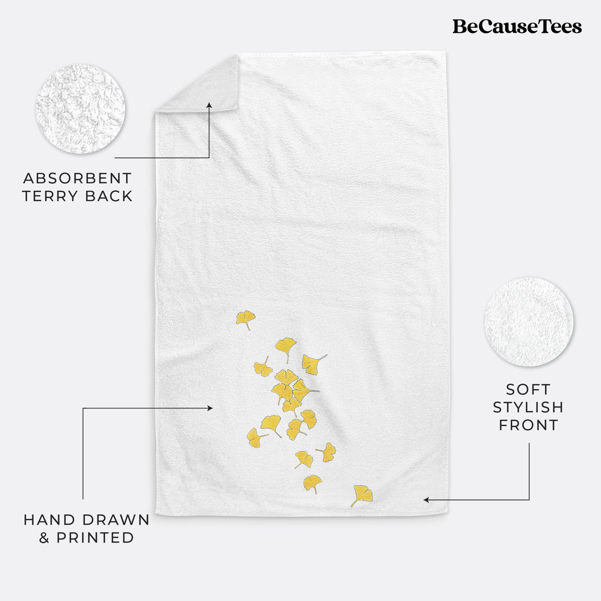 White hand towel printed with a scatter of bright yellow fan-shaped ginkgo leaves falling.