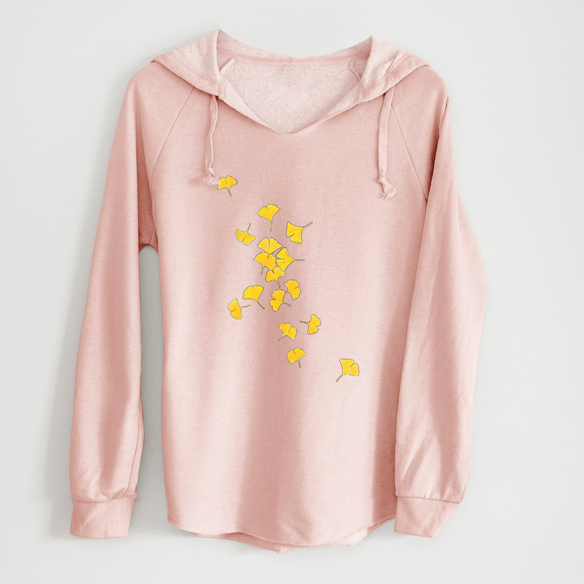 Blush pink women's Cali Wave hooded sweatshirt laid flat, printed with a scatter of bright yellow fan-shaped ginkgo leaves falling.